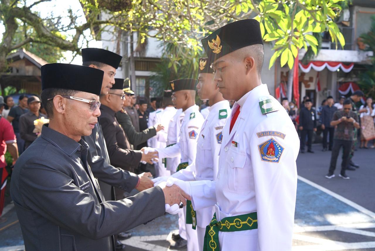 Bupati Klungkung I Made Satria saat mengukuhkan 70 pelajar SMA dan SMK sebagai anggota Pasukan Pengibar Bendera Pusaka (Paskibraka) tahun 2025, di Halaman Kantor Bupati Klungkung, Jumat (15/8/2025). (balihotnews/ist)