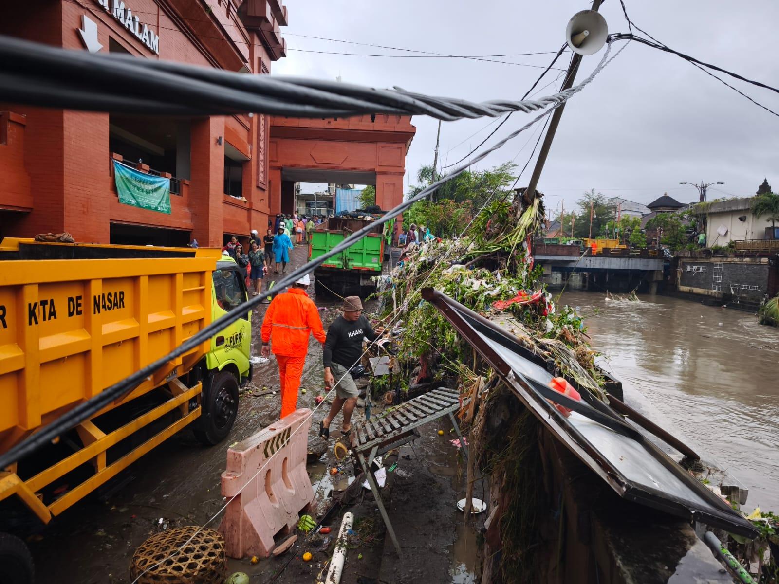 PLN berjibaku lakukan penanganan tiang listrik roboh tergerus longsor akibat cuaca hujan di pasar Kumbasari Denpasar. (balihotnews/pln)