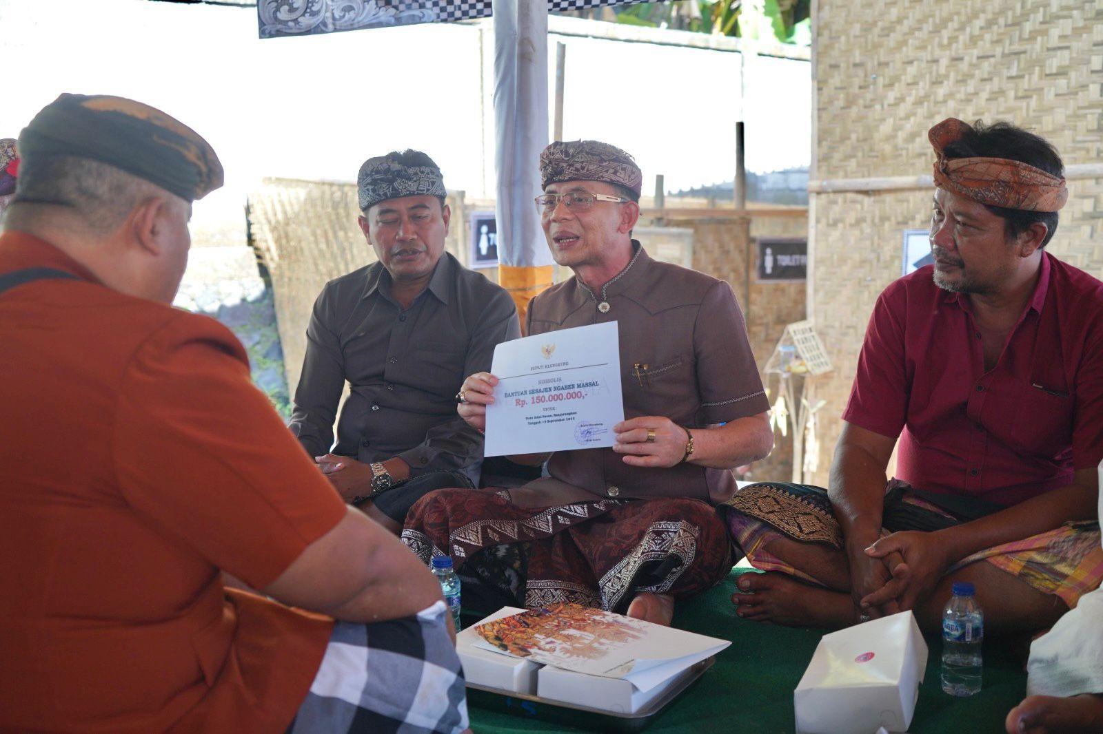Bupati Klunglung, I Made Satria saat menyerahkan punia sesajen ngaben masal senilai Rp150 juta. (balihotnews/pemkabklungkung)