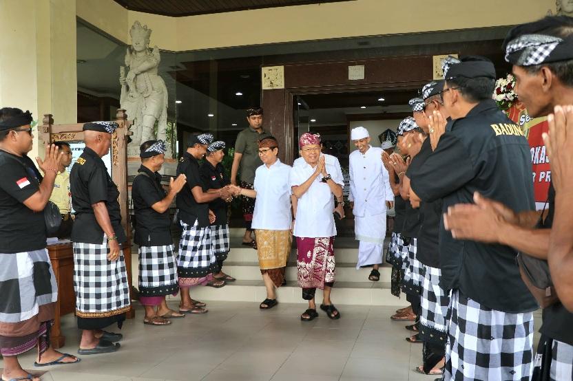 Gubernur Bali Wayan Koster didampingi Bupati Badung Adi Arnawa saat memasuki lokasi Lokasabha XII Maha Gotra Pasek Sanak Sapta Rsi (MGPSSR) Bali di Puspem Badung, Minggu (21/12/2025). (Balihotnews/Ist).