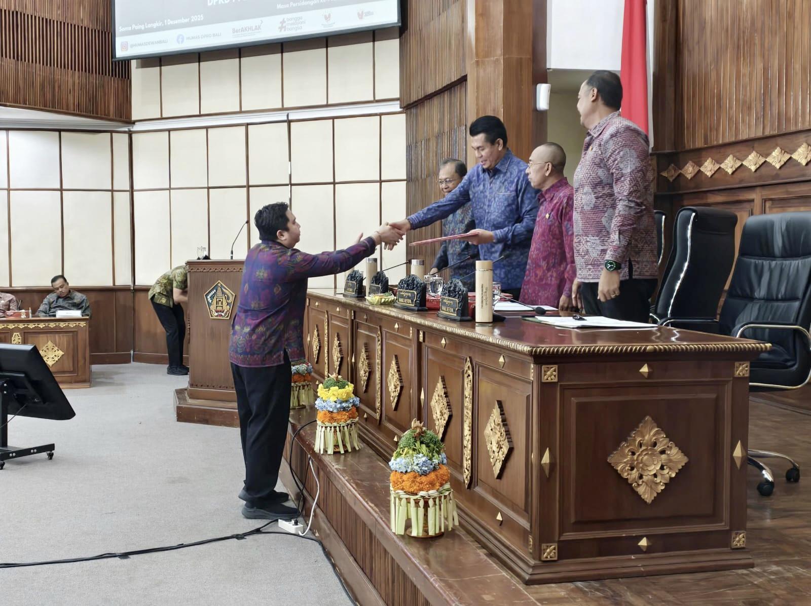 I Gede Ghumi Asvatham (Fraksi Demokrat-NasDem DPRD Bali) menyerahkan pandangan umum fraksi kepada pimpinan DPRD Bali dalam Rapat Paripurna ke-15 Masa Persidangan I, pada Senin (1/12/2025). (Balihotnews/Ist).