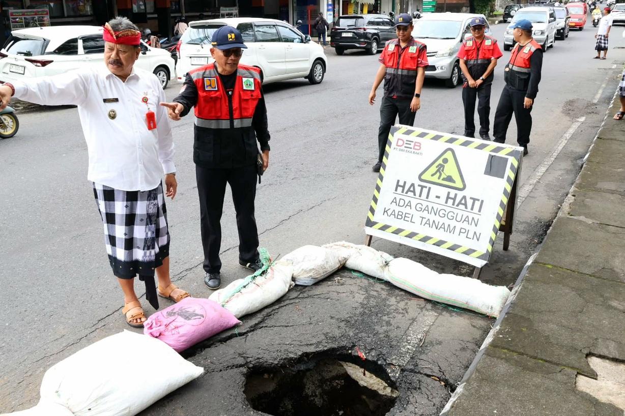 Wakil Bupati Tabanan, I Made Dirga, turun langsung memantau kondisi Jalan Pahlawan (depan Setra Adat Kota Tabanan) yang dilaporkan jebol akibat cuaca ekstrem, pada Kamis (22/1/2026). (Balihotnews/Istimewa)