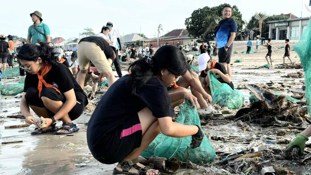 Sejumlah relawan dari Sungai Watch dan Sispala SMAN 1 Kuta bergotong royong membersihkan tumpukan sampah kiriman di Pantai Kedonganan, Badung, Sabtu (24/1/2026). (Balihotnews/red).