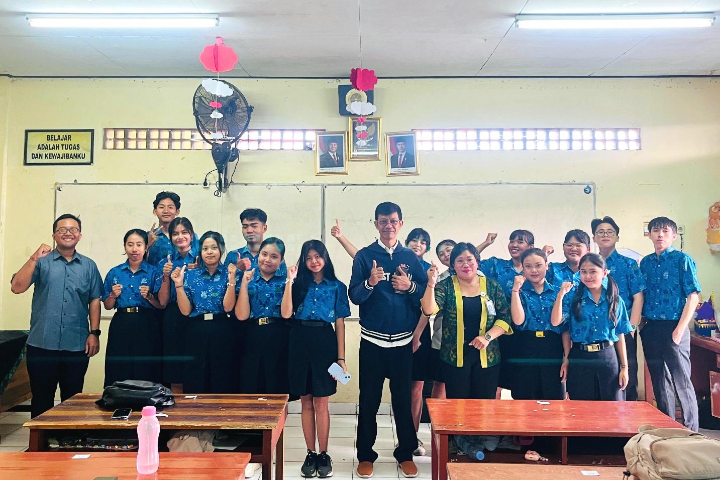 Sejumlah siswa SMK Saraswati 1 Denpasar didampingi pengawas kegiatan, berfoto bersama usai uji kompetensi bahasa Inggris berbasis aplikasi Headway Test, Jumat (13/3/2026). (Balihotnews/Ist)