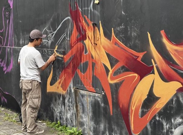 Salah seorang seniman street art saat sedang berkarya, di acara NgabubuArt #3. (dok: istimewa)