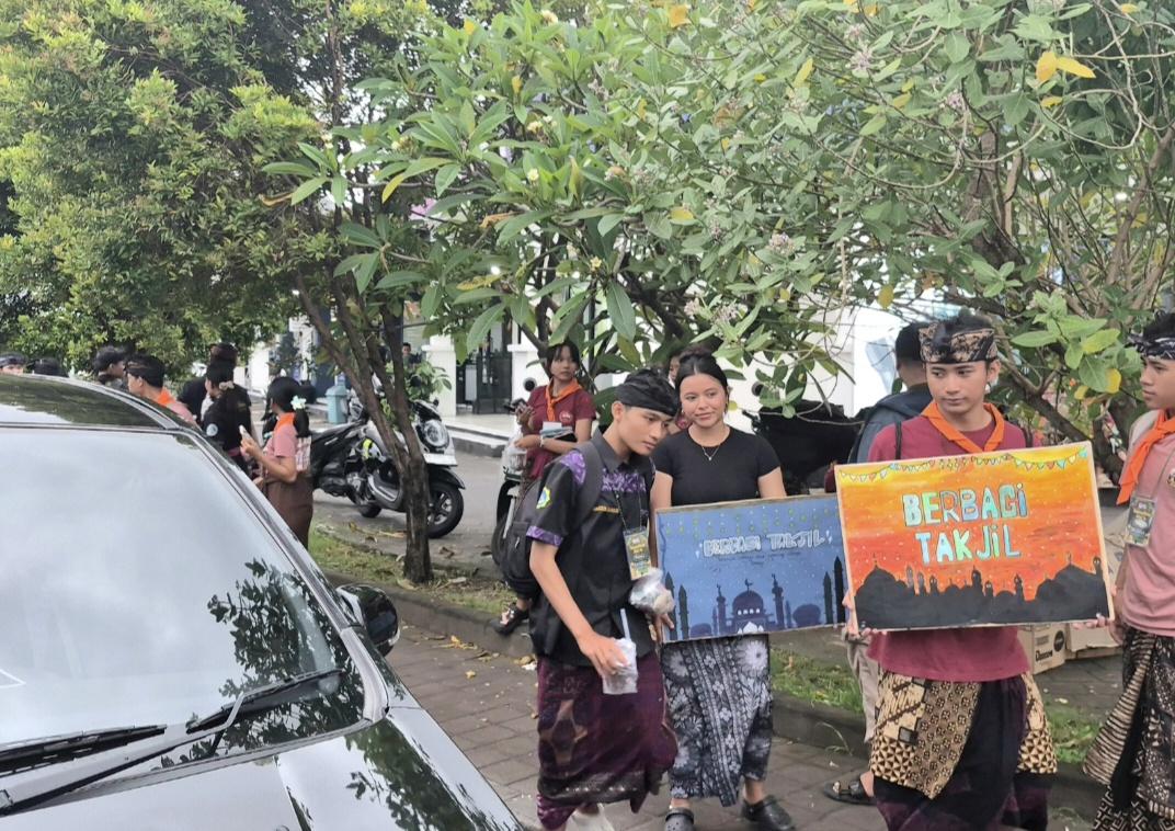 Siswa SMAN 1 Kuta dari ekstrakurikuler Sispala dan Jegeg Bagus membagikan takjil berbuka puasa di simpang Jalan Sunset Road, Seminyak, Badung, Sabtu (14/3/2026). (Balihotnews/dre)