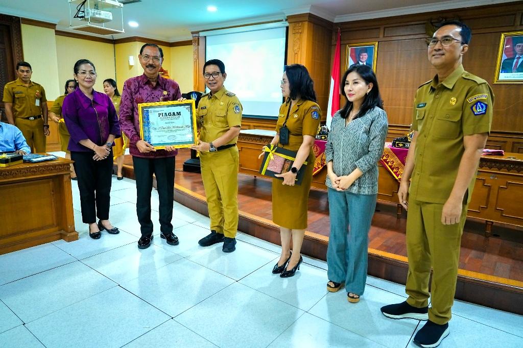 Bupati Badung I Wayan Adi Arnawa memberikan apresiasi kepada I Putu Eka Merthawan (kiri) usai upacara pelepasan pejabat purna tugas di Puspem Badung, Senin (5/1). Bupati Adi Arnawa berharap para senior birokrasi tetap menyumbangkan pemikiran konstruktif bagi pembangunan daerah meski telah pensiun. (Balihotnews/Istimewa)