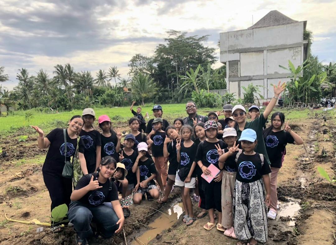 Anak-anak bersama Yayasan Jati Nusa Lestari menanam bibit pohon jati di kawasan rawan longsor Desa Pejeng, Kabupaten Gianyar, Sabtu (10/1/2026) pekan lalu. Kegiatan ini merupakan upaya mitigasi bencana sekaligus edukasi pelestarian alam bagi generasi muda. (Balihotnews/Ist).