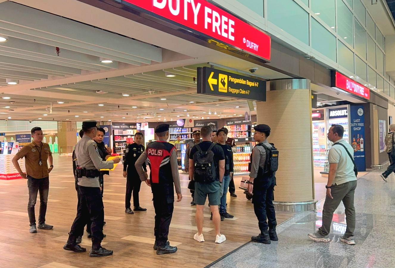 Petugas Imigrasi Ngurah Rai bersama aparat kepolisian mengamankan WN Inggris berinisial SL di Bandara I Gusti Ngurah Rai, Bali, Sabtu (28/3/2026). SL diduga merupakan bos organisasi kriminal internasional. (Balihotnews/Ist)
