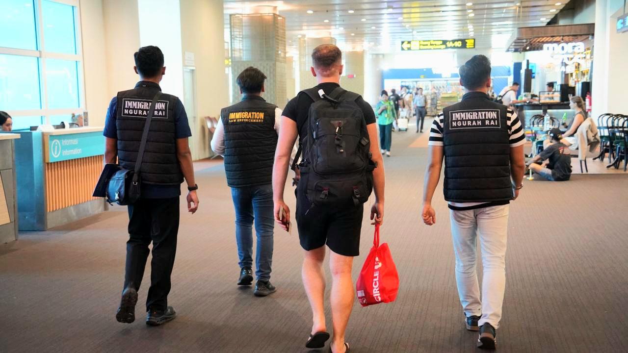 WNA Italia berinisial GI (kedua dari kanan) yang viral melawan polisi, dikawal petugas Imigrasi saat proses pendeportasian di Bandara I Gusti Ngurah Rai, Bali, Selasa (28/4/2026). (Balihotnews/red)