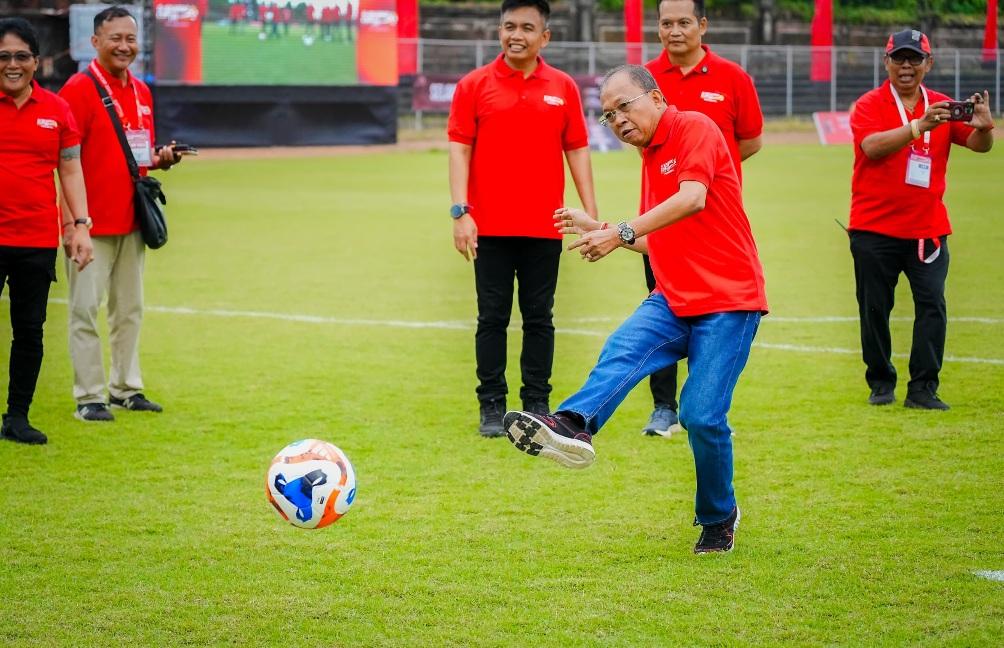 Gubernur Bali yang juga Ketua DPD PDIP Bali Wayan Koster menendang bola sebagai tanda pembukaan Liga Kampung Soekarno Cup III di Stadion Ngurah Rai, Denpasar, Sabtu (9/5/2026). (Balihotnews/red)