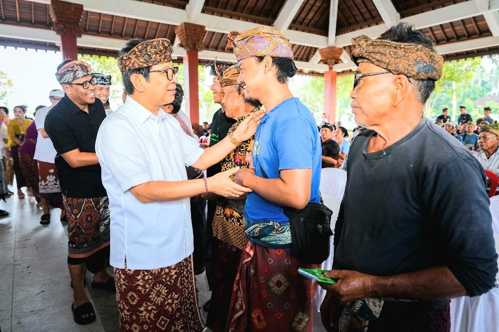 Bupati Badung I Wayan Adi Arnawa menyerahkan bantuan keuangan tunai secara simbolis kepada warga di Wantilan Pura Dalem Desa Adat Blahkiuh, Abiansemal, Badung, Kamis (11/6/2026). (Balihotnews/ist)