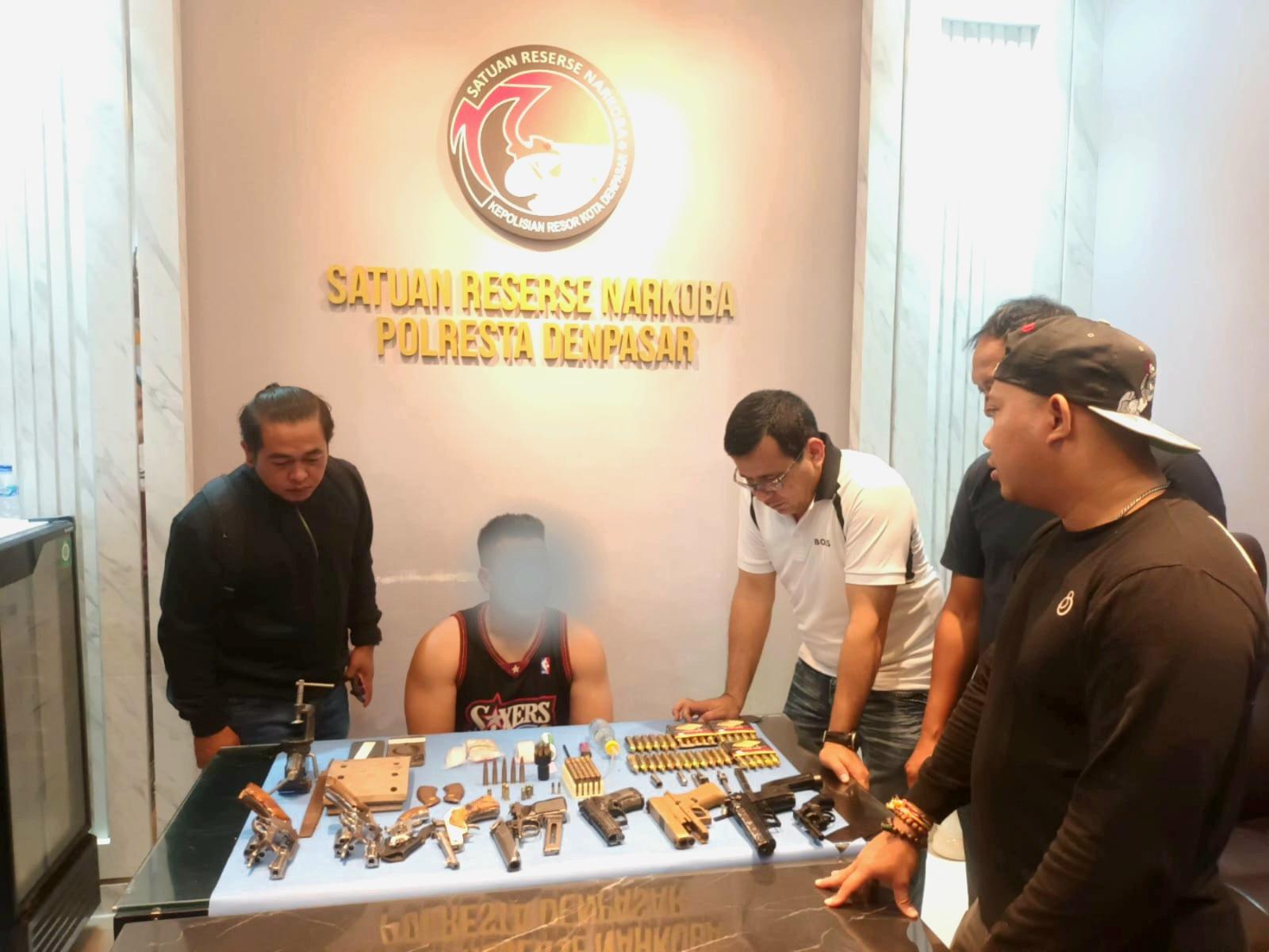 Polisi membeberkan ragam senjata api ilegal dan amunisi hasil sitaan dari rumah tersangka ARMP di Denpasar Timur. (Balihotnews/red)