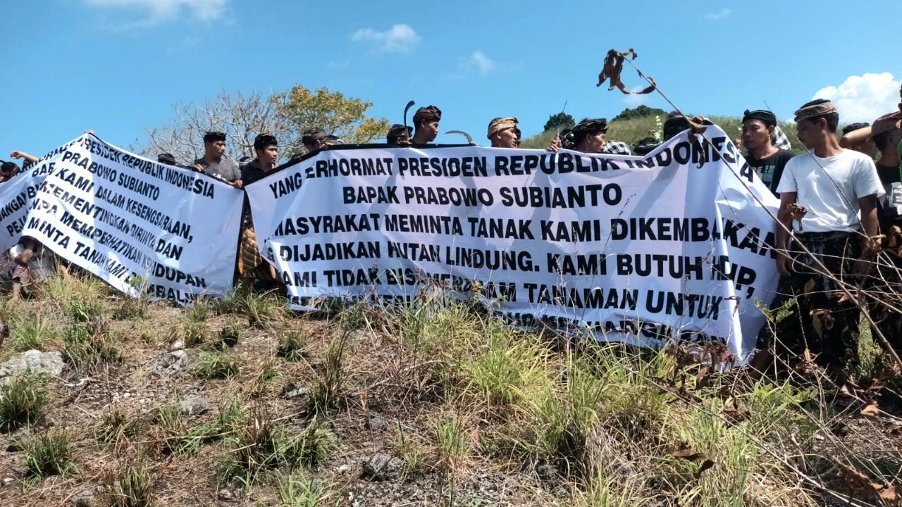 Aksi warga Desa Adat Sekartaji membentangkan spanduk menuntut pengembalian hak atas tanah adat di lahan sengketa Nusa Penida, awal Juni 2026 lalu. (Balihotnews/Ist)
